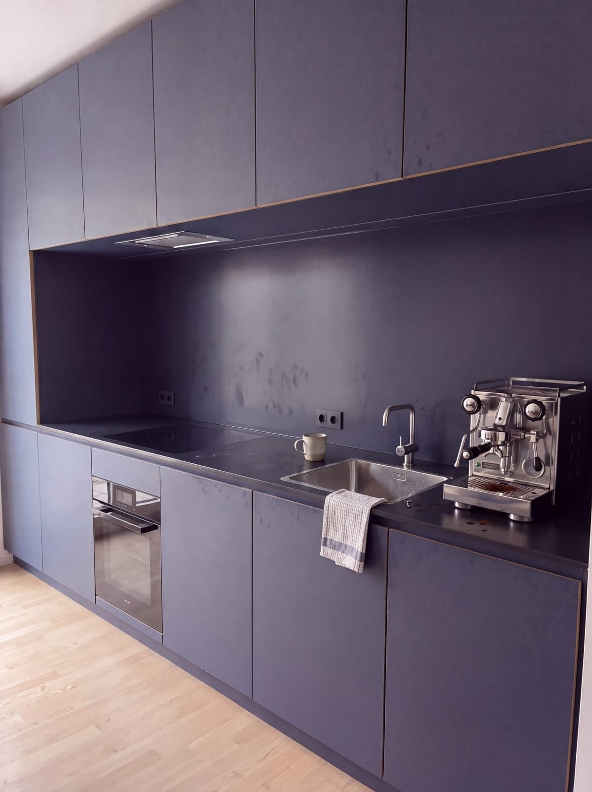 Illustrative example: an office kitchenette with greasy benches, smeared splashback and a dirty sink, before cleaning