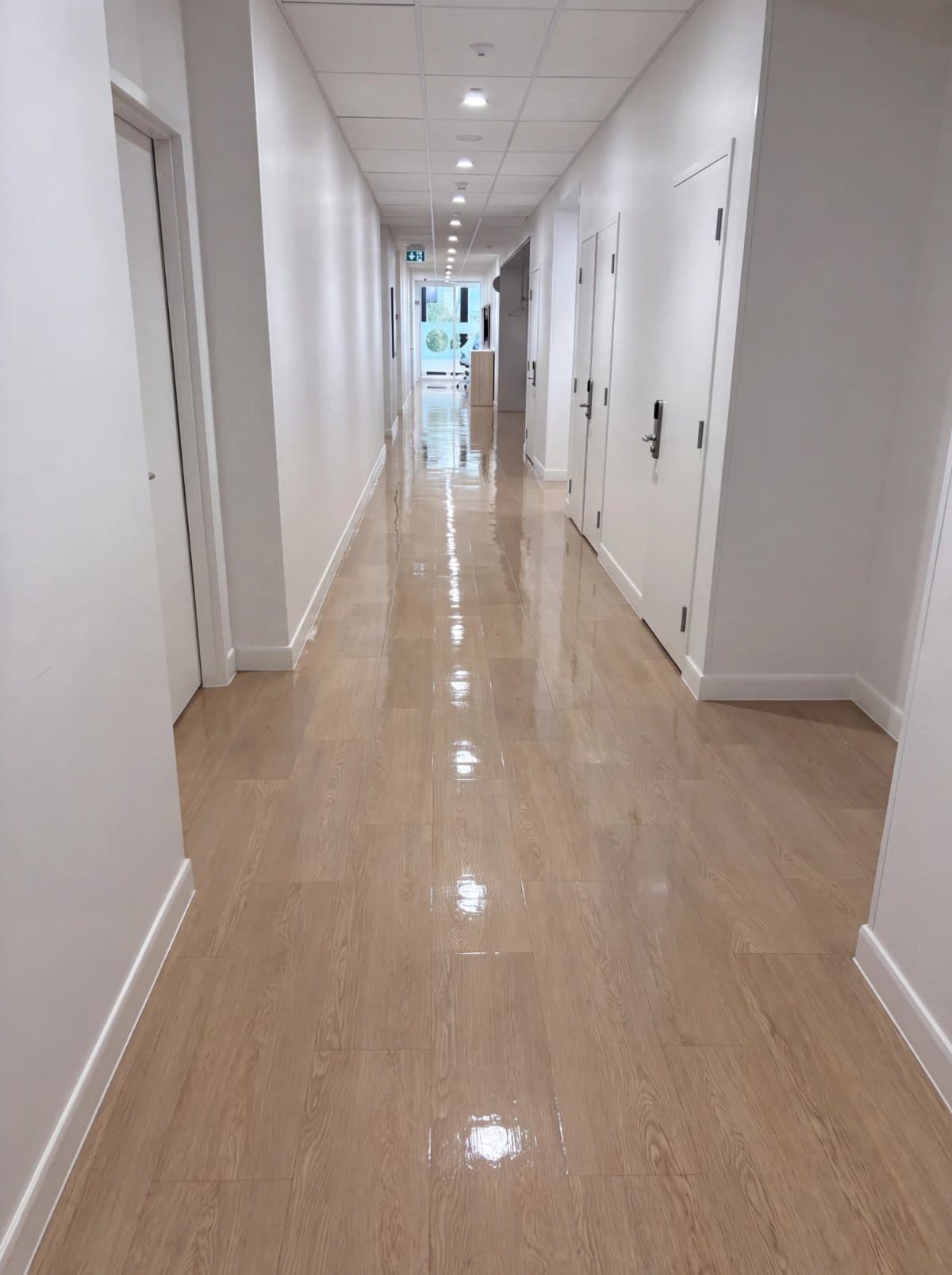 Illustrative example: the same corridor with a clean, high-gloss sealed vinyl floor after strip and seal